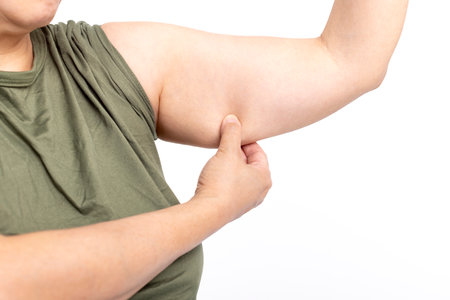 Woman checking her upper arm and excess fatの写真素材