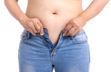 Fat woman trying to wear jeansの写真素材