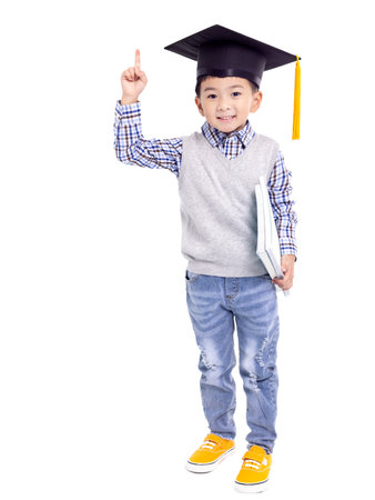 Happy Asian school kid graduate in graduation cap and hand pointing upの写真素材