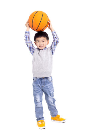 Happy asian Boy holding a basketball and smiling isolated on white backgroundの写真素材
