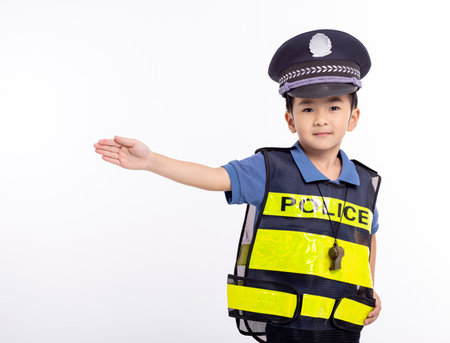 child dressed as a police officer standing before white backgroundの写真素材