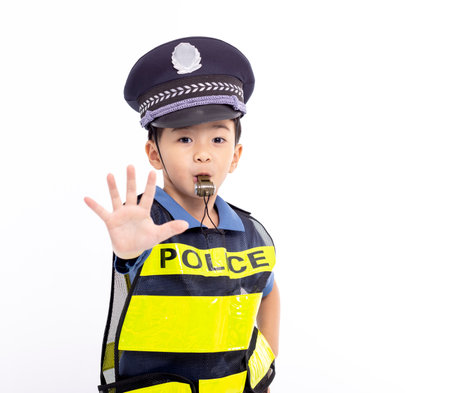 child dressed as a police officer standing and showing stop signの写真素材
