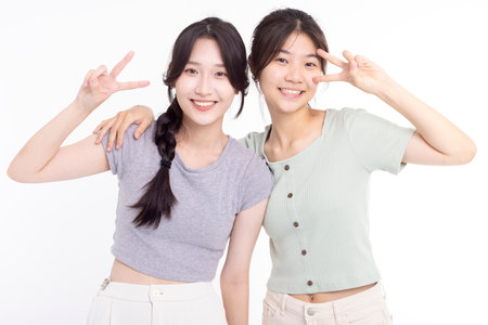 Two young beautiful smiling asian teenager female in summer clothesの写真素材