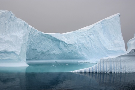 Iceberg floating in the sea, cloudy day