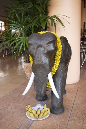 Figure of elephant with food offerings and flower necklace. Usual in Thailand as act of religion.