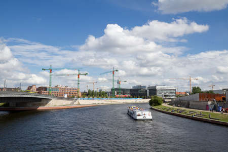 View at river Spree with boat sailing and construction in background, Berlin, Germanyのeditorial素材