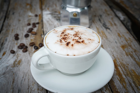 Hot cappuccino in white cup with wooden background,coffee is a popular drink all over the world.の写真素材