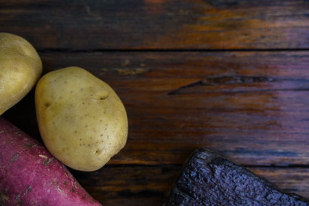 Raw potato diet. Fresh potatoes on wooden floor . Space for messages . Raw potatoes that can be used in many dishes.の写真素材
