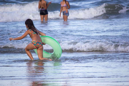 Photo taken of children playing on the beach.
