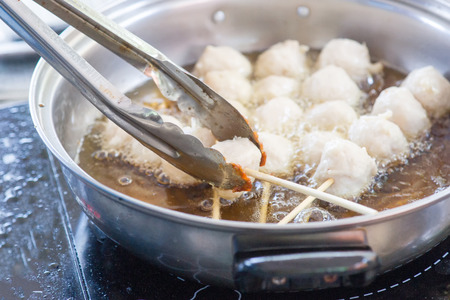 Meatballs Frying in Vegetable Oil in Iron pan on electric stoveの写真素材
