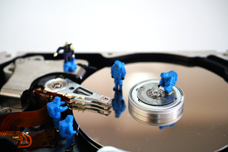 Miniature workers repair harddisk drive