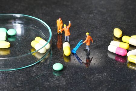 Miniature people - The worker at work with medicine pillsの写真素材