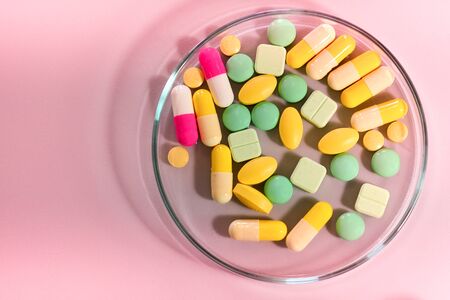 Pharmaceutical medicine pills in petri dish on tableの写真素材