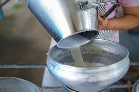 Worker pouring fresh milk into the milk tank for transformの写真素材