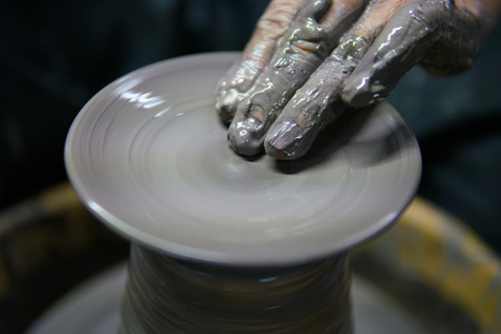 Potter At Work. Man potter making ceramic pot on the pottery wheel