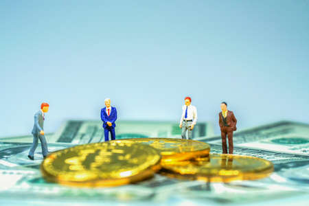 Miniature people : Businessman with golden coin and bills. Business concept.