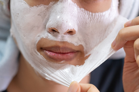 Asian girl applying facial cream mask. facial cosmetic procedure.の写真素材