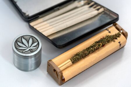 Hands making Marijuana joint from cigarette rolling machine, paper, Making cigarettes with pipe tobacco.の写真素材
