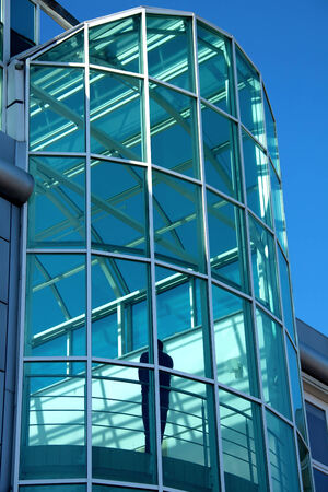 Modern glass building with a silhouette insideの写真素材