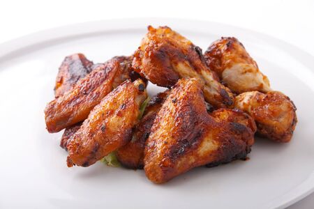 A white plate of delicious barbecue chicken wingsの写真素材