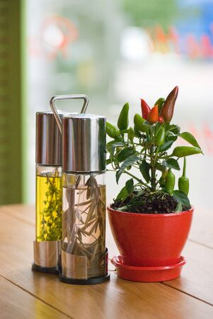 Closeup of vinegar, olive oil and a pot with chili pepper on a table in restaurant. depth of fieldの写真素材