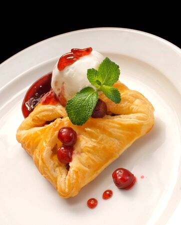 photo of delicious puff pastry with berries and ice cream on a white plateの写真素材