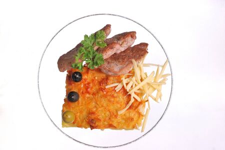 Cheese casserole with slises of grilled meat on white background on a transparent plate, close up.の写真素材
