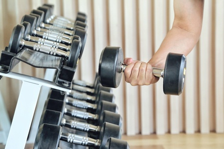 Close up of man holding weight in gym. fitness concept. holding dumbbell in fitness center. concept of healthyの写真素材