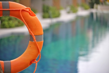 Lifebuoy,Life preserver,Life ring,Life belt  hanging at the public swimming pool in the blur background. To show concept of safety.の写真素材