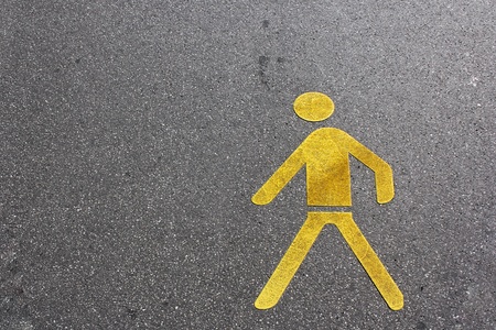 pedestrian lane sign in yellow on the asphalt groundの写真素材
