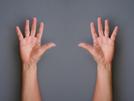 hands making raise hands up on gray backgroundの写真素材