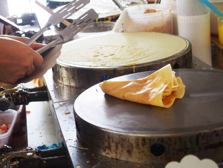 process of cooking pancake or dessert crepe on a hot plateの写真素材
