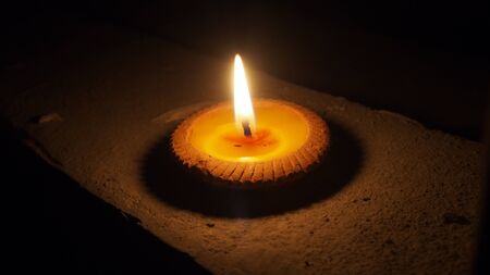 burning flat candle at night isolated on dark background