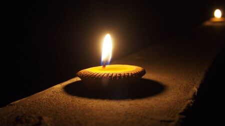 burning flat candle at night isolated on dark backgroundの写真素材