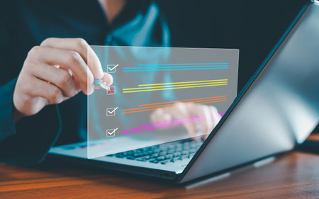 Businessman working on laptop computer productivity checklist and filling survey form online. Document management system. DMS. Assessment form, questionnaire, checklist and clipboard task management.の写真素材