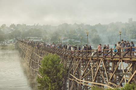 Kanchanaburi,Thailand-December,30,2016:Unidentified Tourist walk on the wooden bridge over the river in morning with fog and veil of mist at Sangkhlaburi, Mon Bridge is the longest bridge in Thailandのeditorial素材