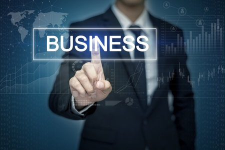 Businessman hand touching BUSINESS button on virtual screenの写真素材