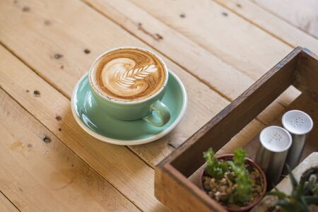 hot cappuccino with latte art on wood backgroundの写真素材