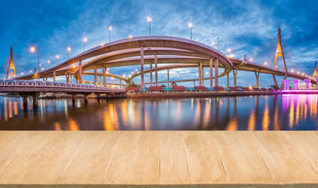 Wood floor with background of downtown and bridge at eveningのeditorial素材