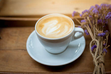 hot latte art on wood table backgroundの写真素材