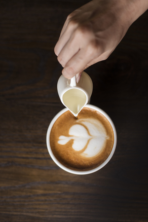 Hot latte art on wood tableの写真素材