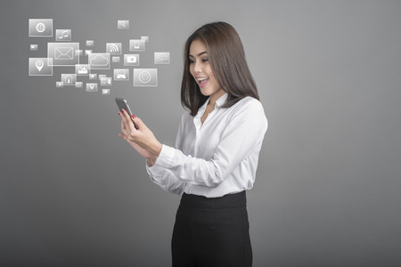 Beautiful business Woman using smartphone on grey background
