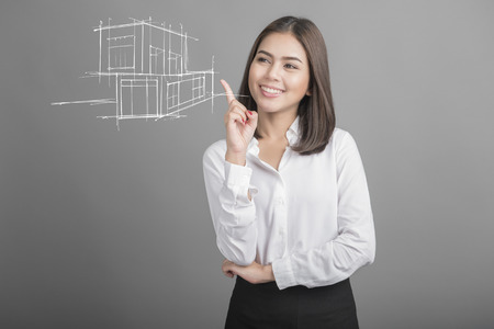 Beautiful Business Woman presenting real estate a model of the houseの写真素材