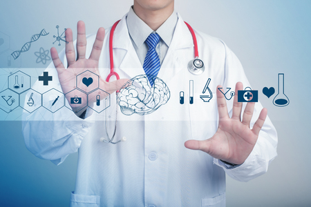 Medicine doctor hand holding stethoscope and working with modern medical iconsの写真素材