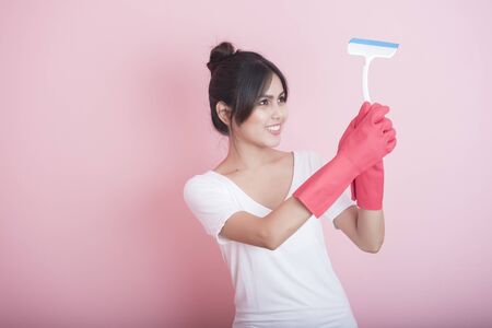 Beautiful asian housewife smiling on pink backgroundの写真素材