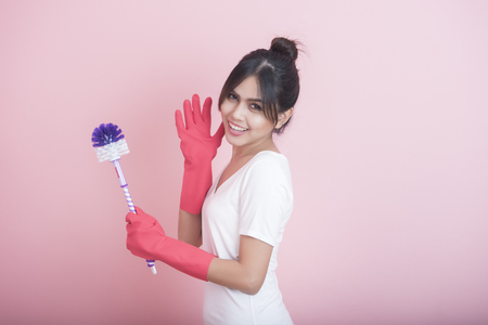 Beautiful asian housewife smiling on pink backgroundの写真素材