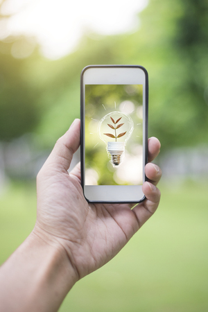 Close up man hand using smartphone with ecology sign, Save earth conceptの写真素材