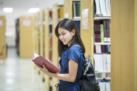 Beautiful women asian university student in libraryの写真素材