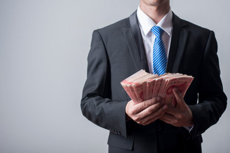 Business man holding China moneyの写真素材