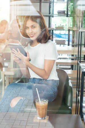 Beautiful business girl working with tablet , smartphone and drinking coffee in coffee shopの写真素材